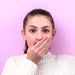 Frau hält sich verlegen die Hand vor den Mund